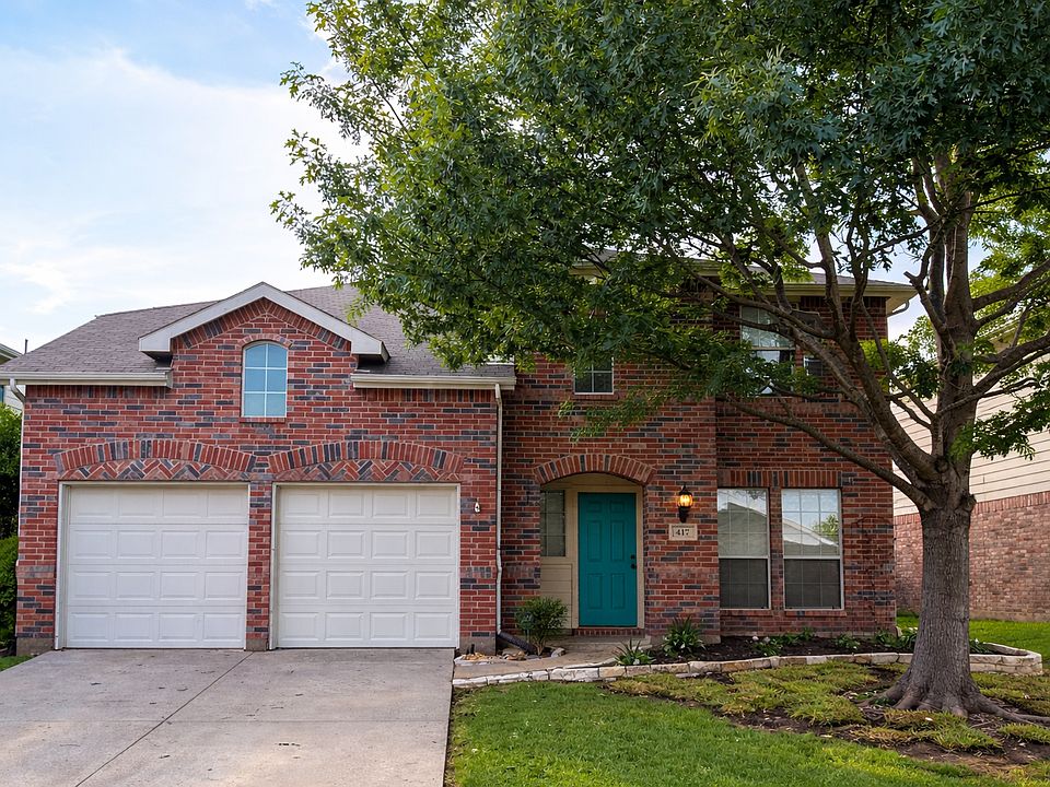 Front yard with attached 2-car garage, large tree and a nice sized yard.