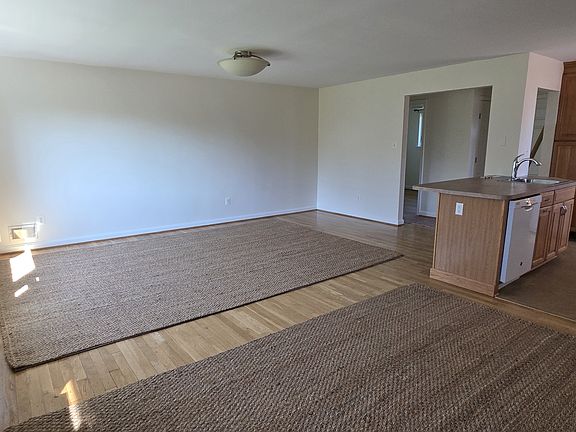 Great room view from dining room shown with area rugs