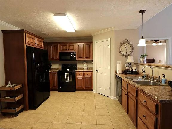 Kitchen has side by side refrigerator with ice and water in door, full size range, microwave, garbage disposal.