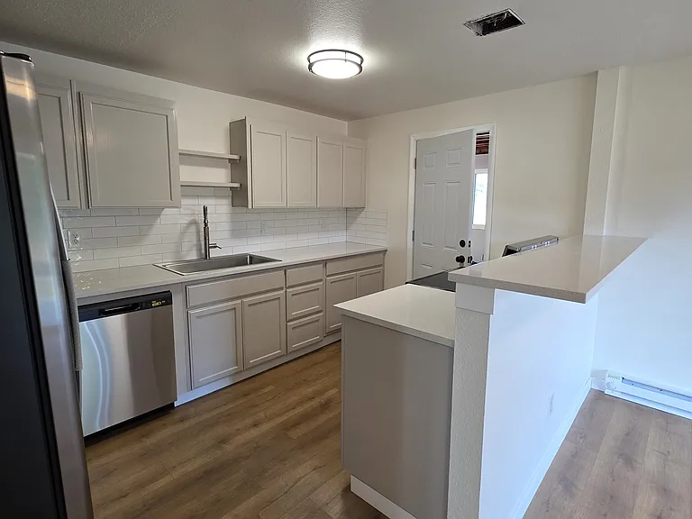 Another view of the kitchen with LVP flooring and quartz counter tops