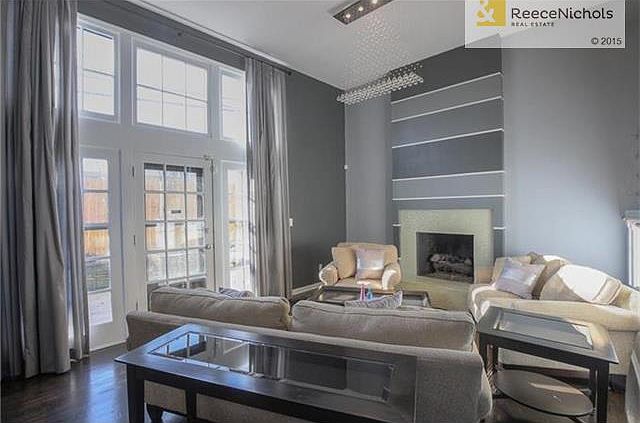 Floor to ceiling windows with custom drapery, updated fireplace and designer lighting