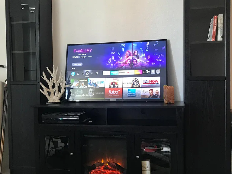Cozy electric fireplace with or without heat beneath a new smart tv with streaming channels or use the full cable channels.
