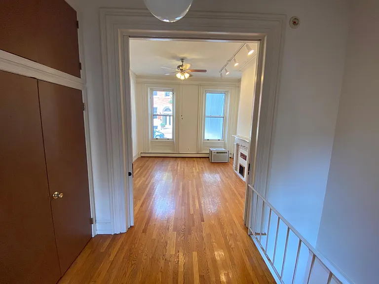 FROM HALLWAY INTO FIRST FLOOR BEDROOM CEILING FAN WITH LIGHT SOURCE, MANTLE ON LEFT. POCKET DOORS. CLTH CLOSET ON LEFT