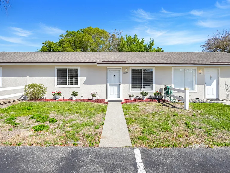 Welcoming front entrance with beautifully maintained flower beds, plus one designated parking space and adjacent guest parking.Welcoming front entrance with beautifully maintained flower beds, plus one designated parking space and adjacent guest parking.