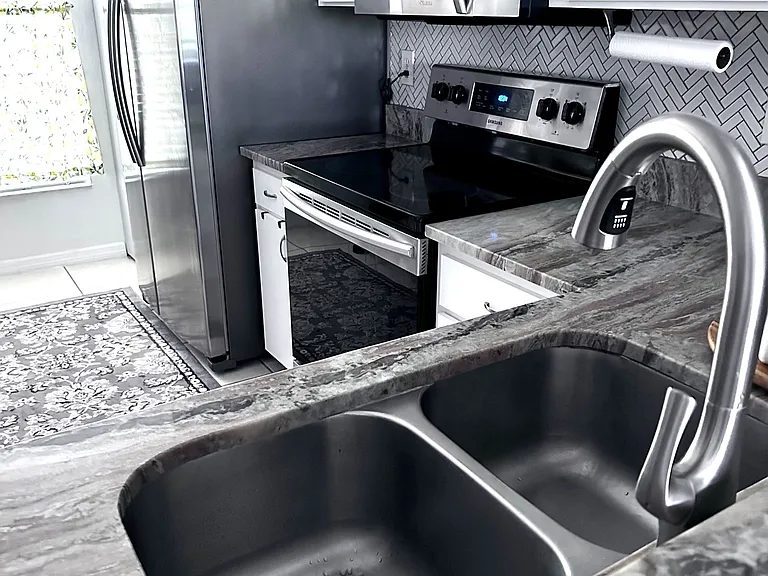 Kitchen with updated granite countertops and tile backsplash