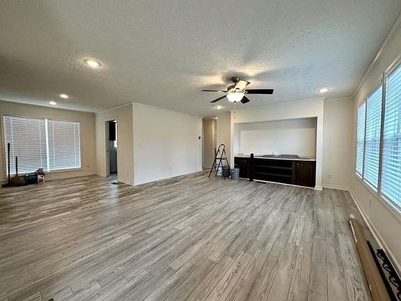 Right side is Living room upgraded with ceiling fan, ceiling lights whole house, with built in 65' TV Cabinet with drawers