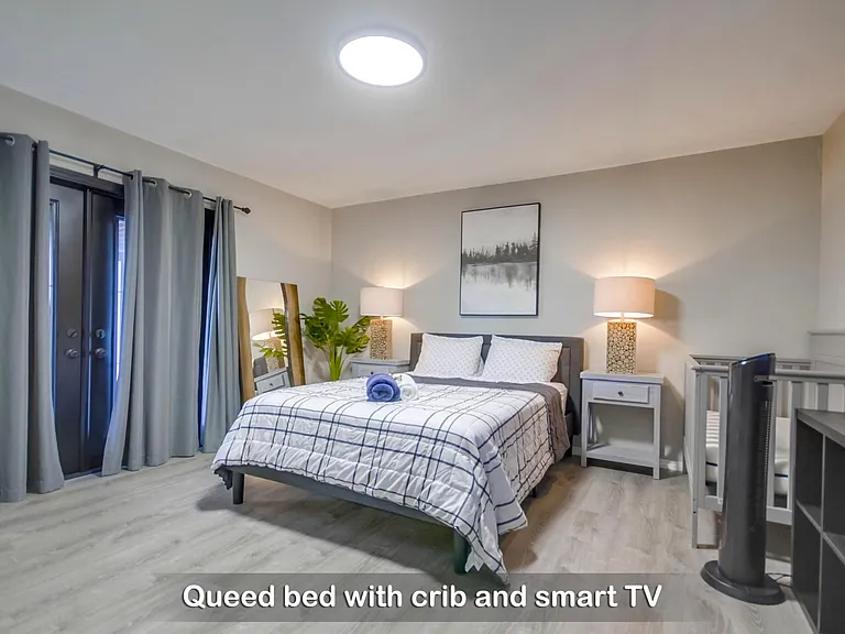 The master bedroom is well-decorated w/ a queen bed, TV & crib for your little ones