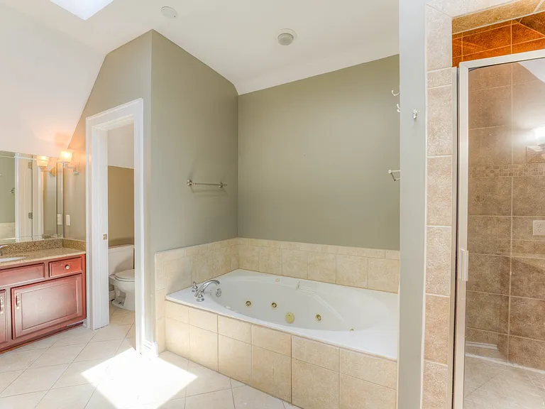 Master bathroom 2 upstairs with skylight. This gives you a bright bathroom with natural light. Through the water closet is a door to the walk in storage area.