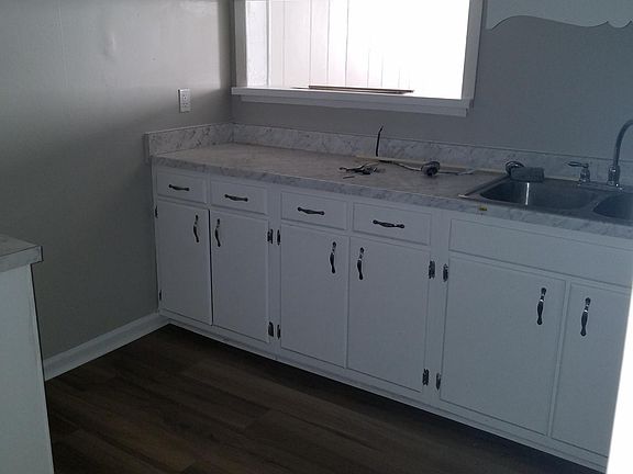 Kitchen with new counter tops and painted cabinets and new hardware.