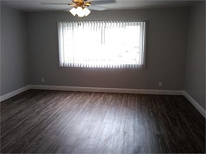 Spacious living room with ceiling fan and hardwood floors