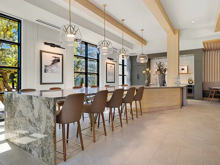 Sunlit dining area with stone table and pendant lighting