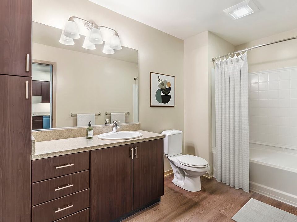 Renovated Package I bath with grey speckled granite countertop, espresso cabinetry, and hard surface flooring