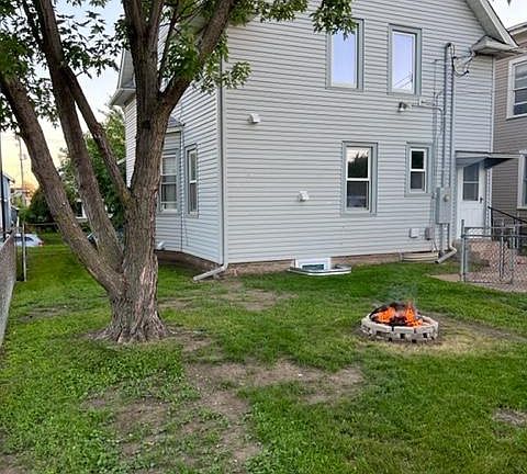 Backyard with firepit and garden beds.