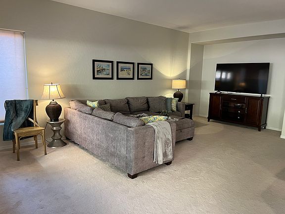 Comfortable sectional and 65 inch TV in living room.