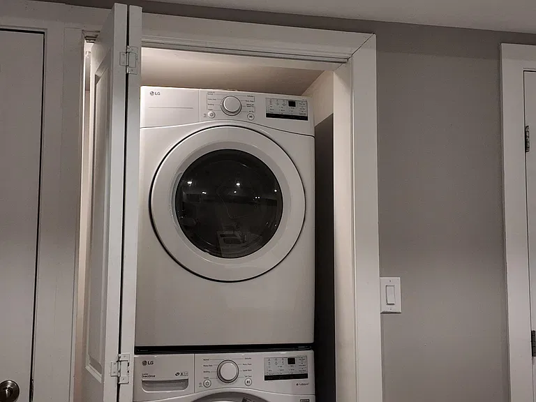 Convenient in-home laundry closet with a stacked front-load washer and dryer for easy, everyday use.