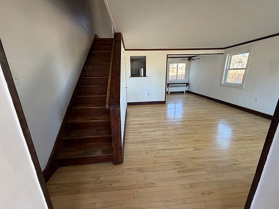 View of the apartment upon entry from the front door. Living room includes dining area and storage under stairs. There is also an entry closet - this unit has plenty of storage space.