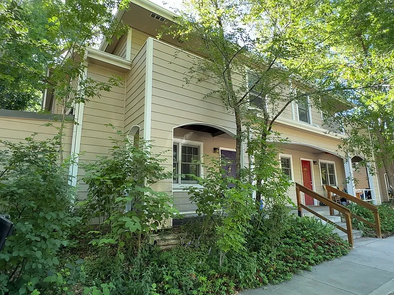 Another view of Remington Place Townhomes, showcasing the private entrances, mature landscaping, and peaceful setting.