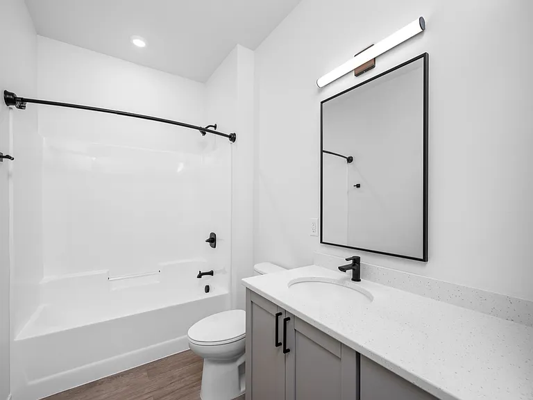 Modern bathroom with sleek black fixtures, spacious bathtub, and elegant vanity with a bright, minimalist design. Modern bathroom with sleek black fixtures, spacious bathtub, and elegant vanity with a bright, minimalist design.