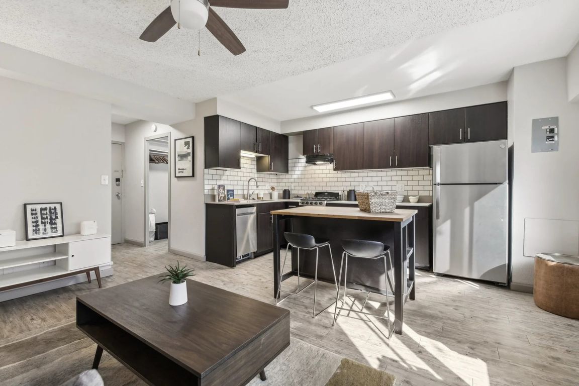 The kitchen area is updated for a modern look with dark wood cabinets and updated appliances