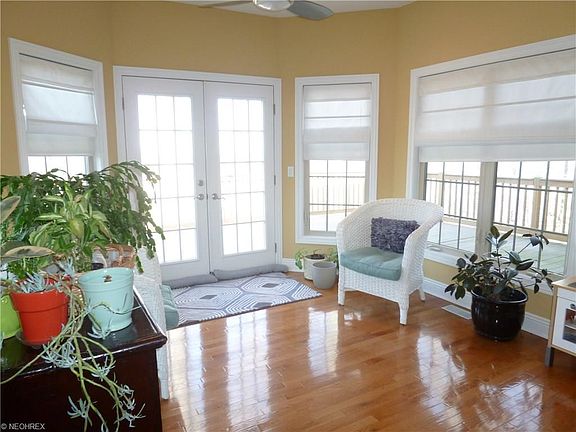 BEAUTIFUL SUN ROOM OF ALL WINDOWS, CEILING FAN, HARDWOOD FLOORS AND FRENCH DOORS TO WOOD DECK