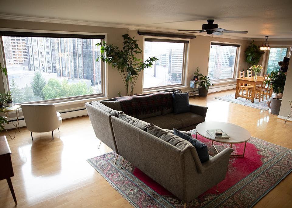 Open plan living room into dining area with large windows, 180-degree views of the city