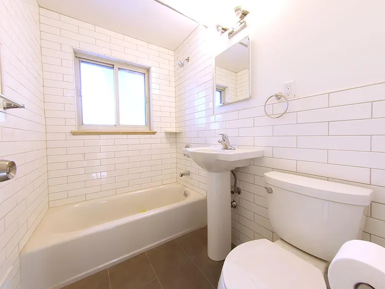 Fully remodeled bathroom featuring subway tile, Kohler fixtures, new bathtub/shower and medicine cabinet.