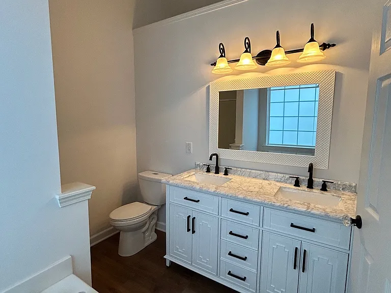 Master bath with gorgeous free-standing vanity with Carrara marble countertop and double sinks