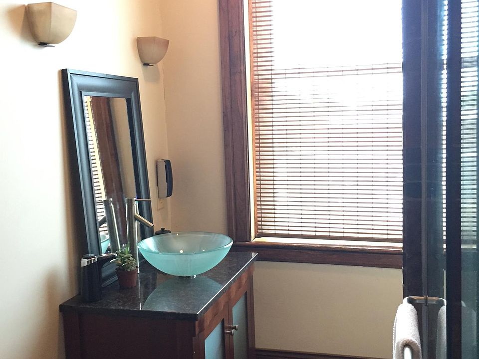 The bath features custom cabinetry a tall chest provides ample storage & drawers, while the matching vanity and vessel sink adds a ton of charm and character.