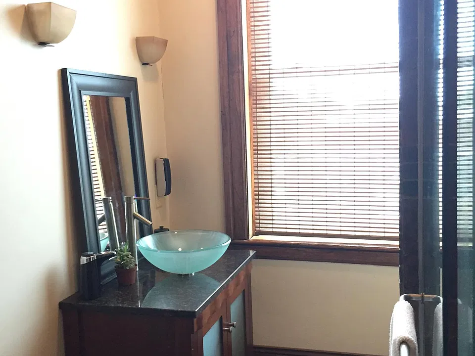 The bath features custom cabinetry a tall chest provides ample storage & drawers, while the matching vanity and vessel sink adds a ton of charm and character.