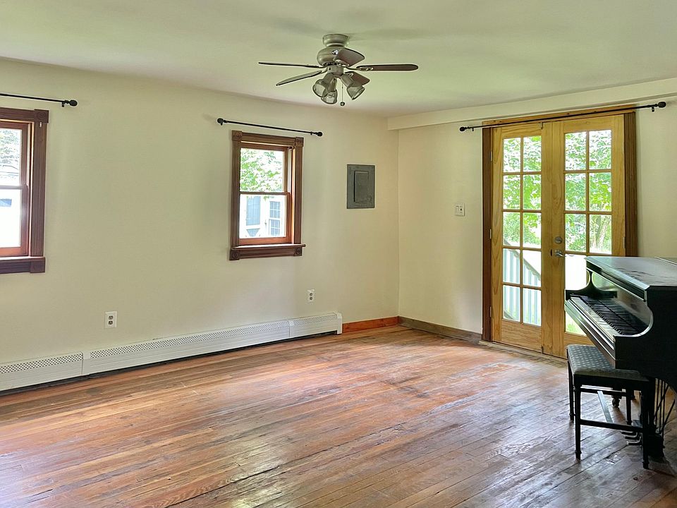 Expansive living room with piano and french doors to back.