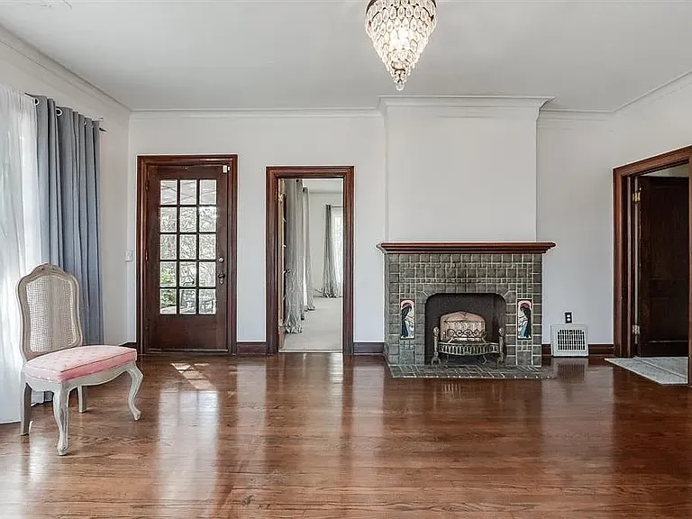 Living room view toward outside patio door on far left and bedroom 1 door left of fireplace.