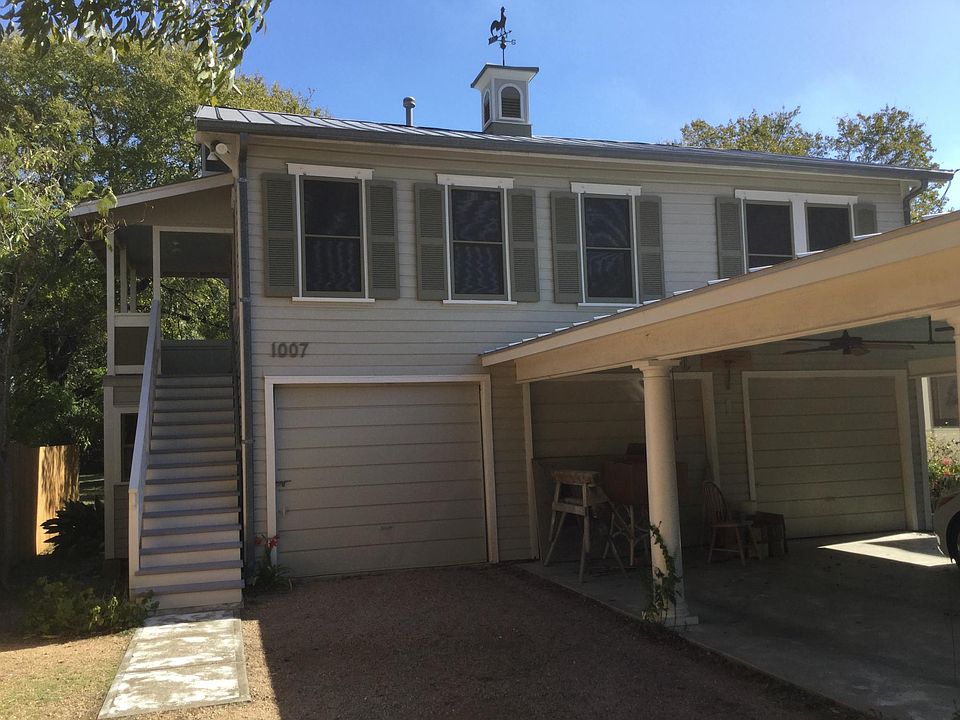 Exterior of garage apartment, staircase, 2nd floor porch, single garage below has utility connections. Owner uses the carport.