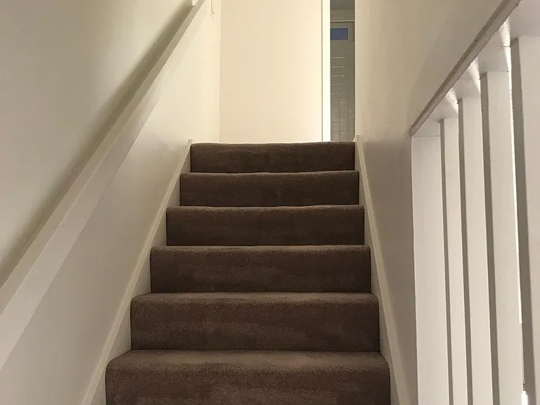 Stairs from living room to bedrooms and bathroom.
