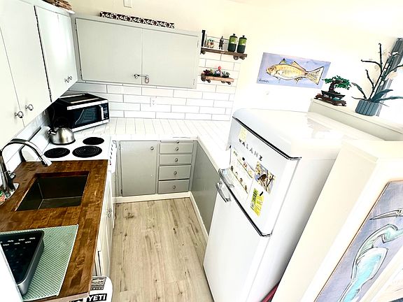 Retro fridge, subway tiles, butcher block and tile counters create a clean, functional kitchen.