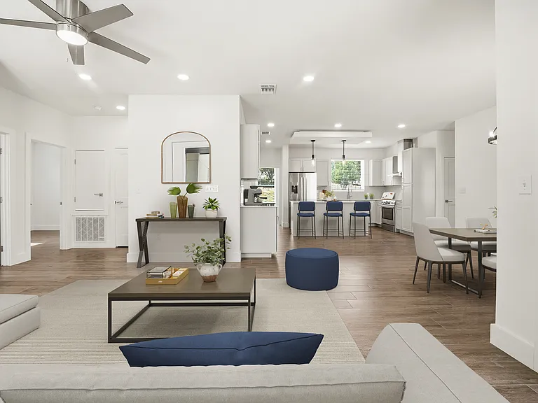 Light-filled open-concept living space with wood-look tile flooring, recessed lighting, and a sleek modern ceiling fan.