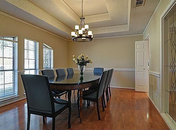 Spacious Formal Dining Room features a Custom Tray Ceiling and Designer Chandelier.