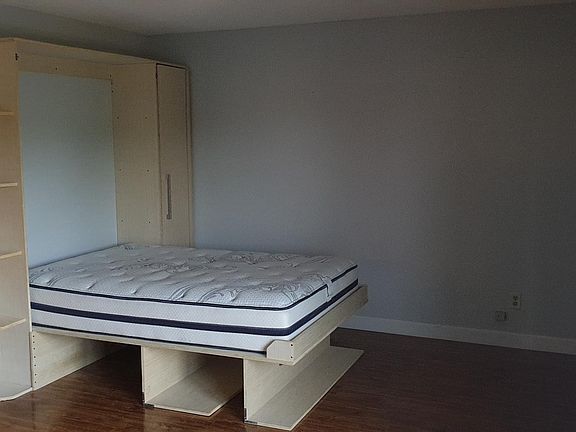 living room with custom murphy bed - convertible office space to a guest bed
