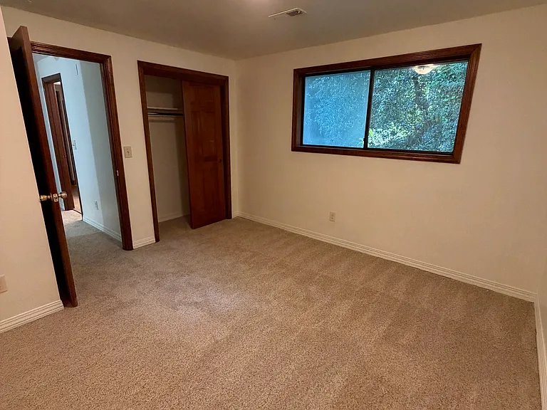 3rd floor bedroom 3 w/ closet and view of forest area