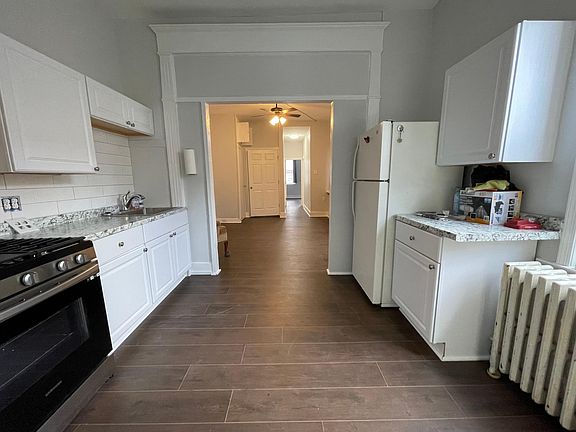 View from kitchen through living room into bedroom at far end