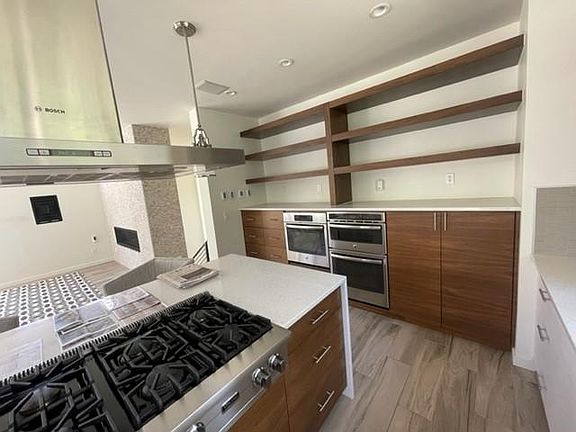 8 burner stove, 2 ovens and shelving/cabinets in kitchen