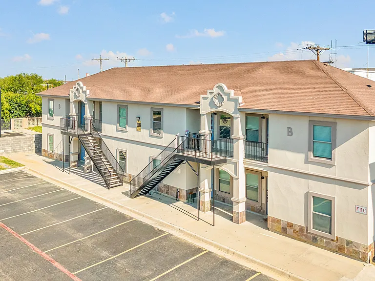 Exterior view of Merida Vista Apartments in Laredo, Texas, located at the corner of a parking lot