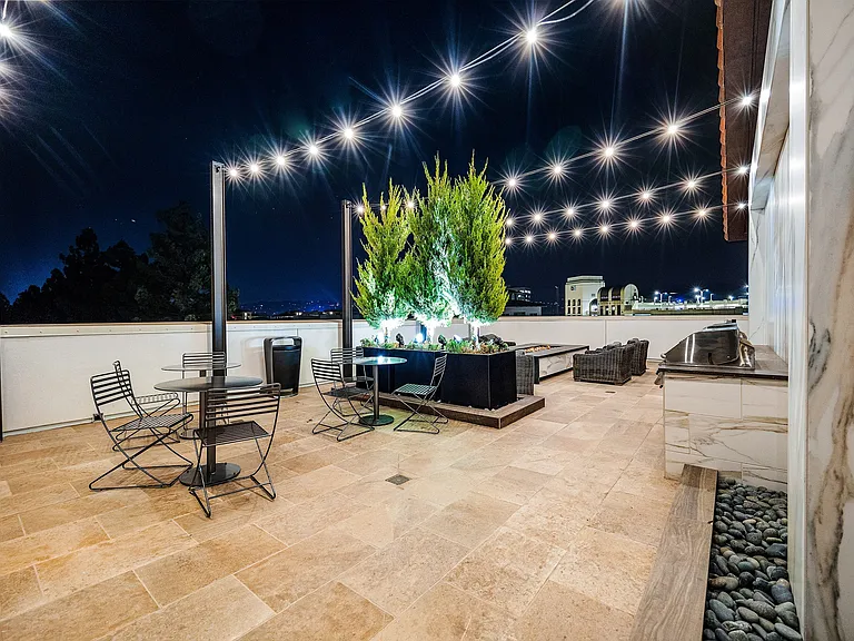 Rooftop terrace with fire pit, string lights, and lounge seating