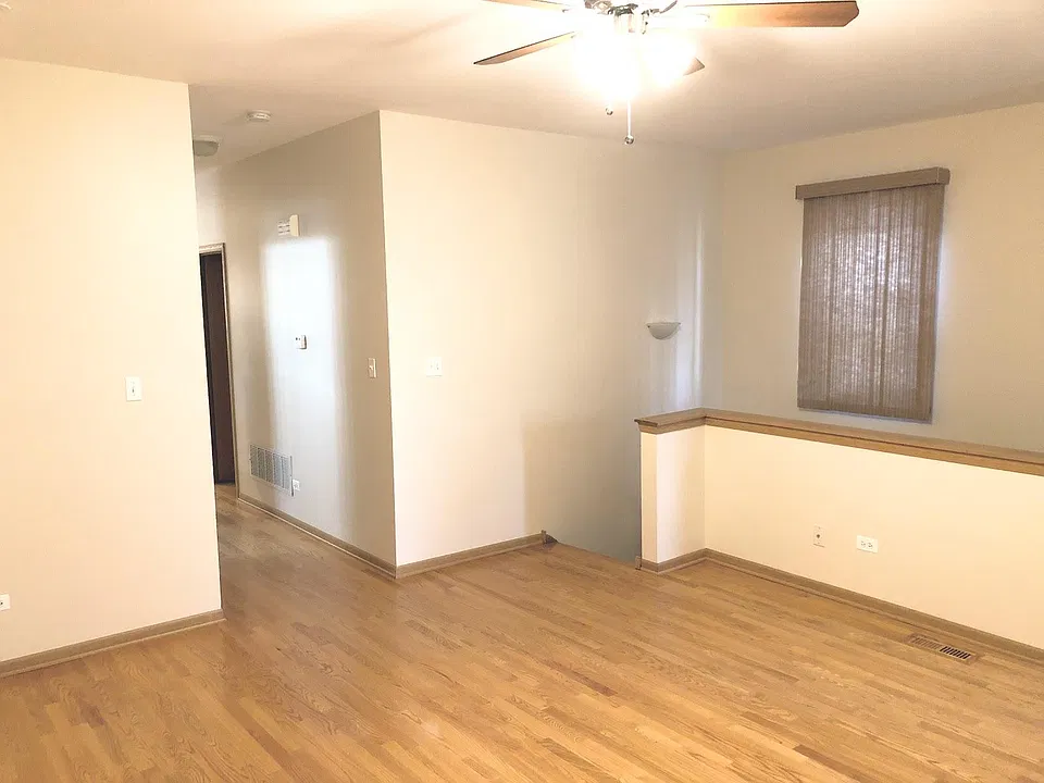 Large living room is hardwood, stairs lead to basement bedroom and more