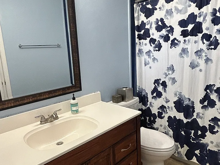 Additional view of the front bathroom with the vanity and large mirror.