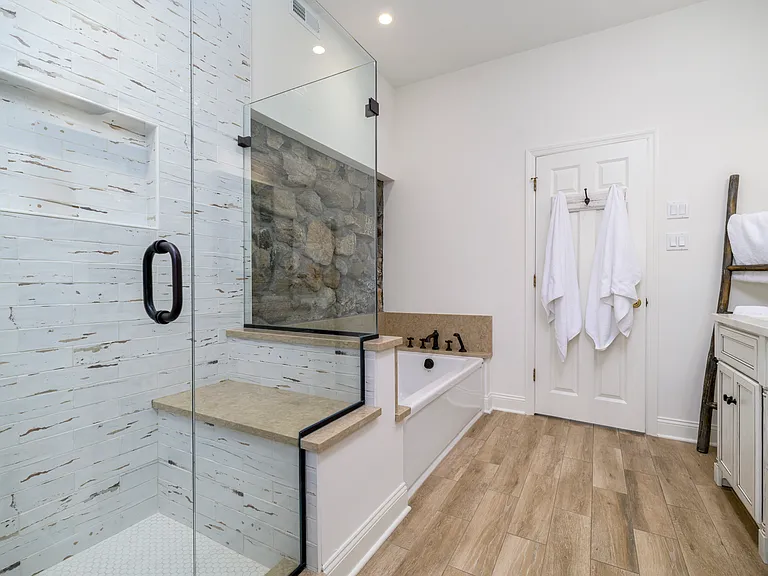 Walk-in shower with separate bathtub with the original stone work.
