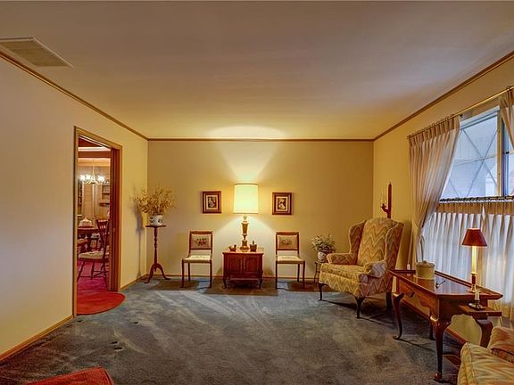 This is the Formal Living/Dining area with large front window.  Plenty of room for guests. The rooms to the left iare the den and the kitchen,  The red carpet is gone, so don't let that deter you!