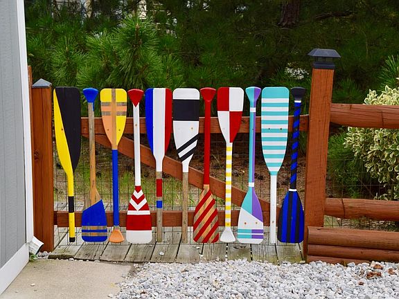 Colorful oars decorating the gate to the house.