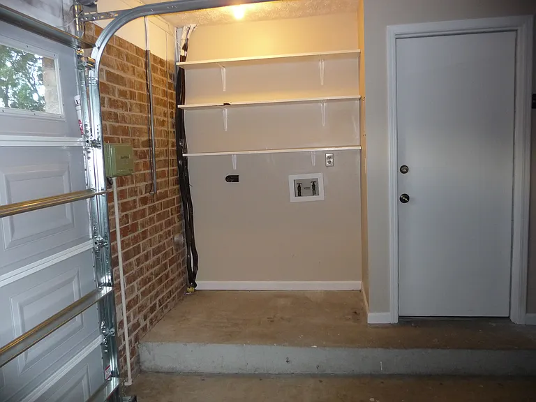 Laundry area in garage with door into kitchen.