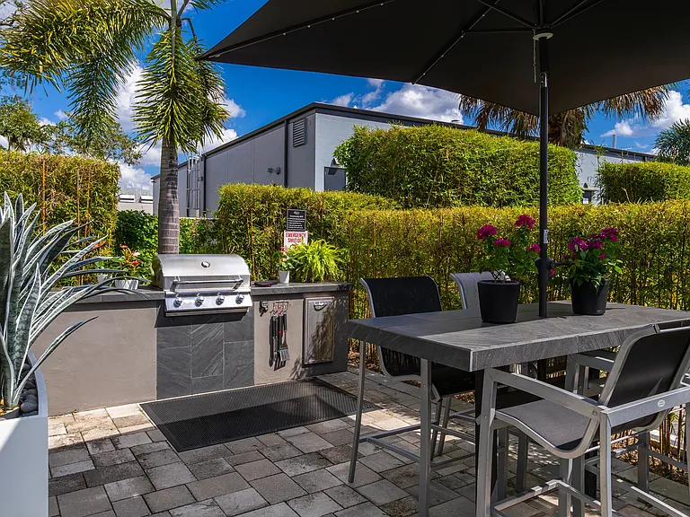 Enjoy an outdoor meal at our beautifully landscaped lounge area, complete with a BBQ grill and shaded seating.