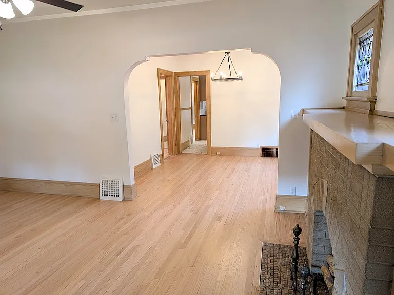 View from back of living room looking into dining room which leads into kitchen (straight) and master bedroom (left of dining room)